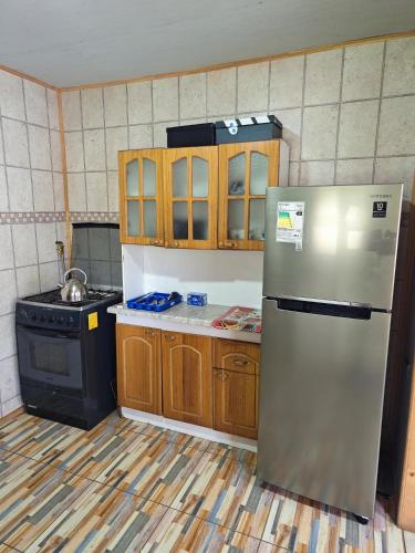 a kitchen with a stainless steel refrigerator and a stove at Cabañas del real in San Fabián de Alico