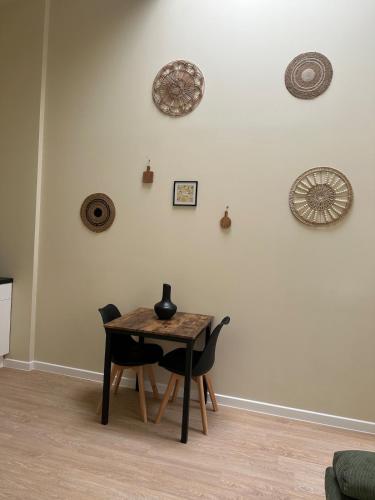 a table and chairs in a room with a wall at Appartement cosy gare chateaucreux in Saint-Étienne