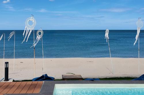 a view of the beach with kites on the beach at เดอะซีน คาบาน่า บีช รีสอร์ท ขนอม The Scene Cabana Beach Resort Khanom in Ban Plau