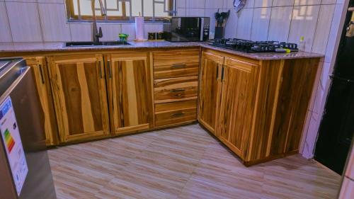 a kitchen with wooden cabinets and a counter top at JMG Homes & Apartment in Dodoma