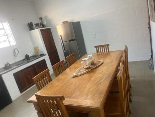 a kitchen with a wooden table with chairs and a refrigerator at Casa Temporada in Rio das Ostras