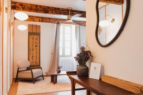 a living room with a table and a mirror at La suite Kyoto, appartement privé Uzès in Uzès