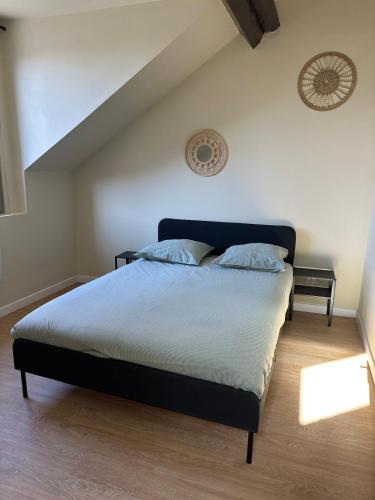 a bedroom with a large bed with blue pillows at Appartement 2 chambres gare chateaucreux in Saint-Étienne