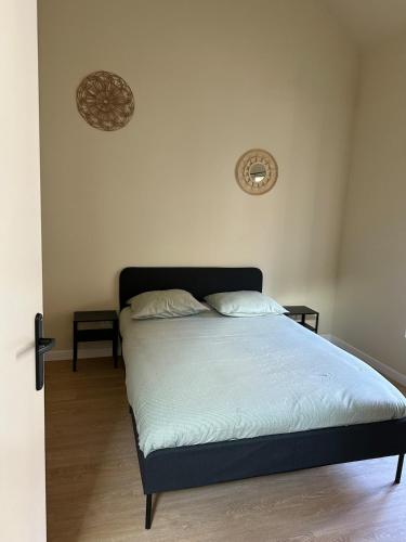 a bed in a bedroom with two pillows on it at Appartement 2 chambres gare chateaucreux in Saint-Étienne