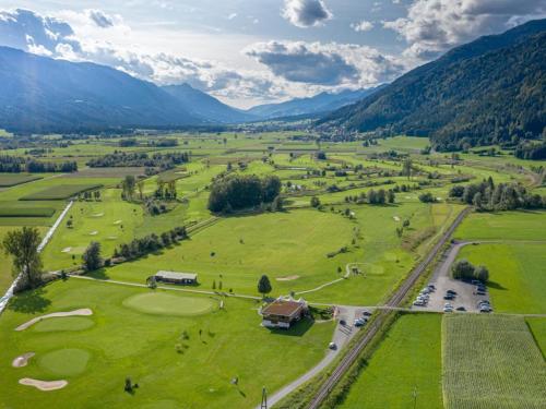 an aerial view of a golf course with mountains in the background at Alpine Oasis in Hermagor