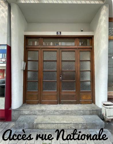 a pair of wooden doors on a building at Le cocon du Centre in Dunkerque