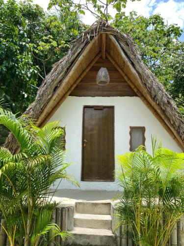 a small house with stairs leading to a door at Eco Hotel Amanecer Tayrona in El Zaino