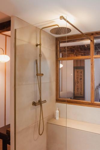 a shower with a glass door in a bathroom at La suite Kyoto, appartement privé Uzès in Uzès
