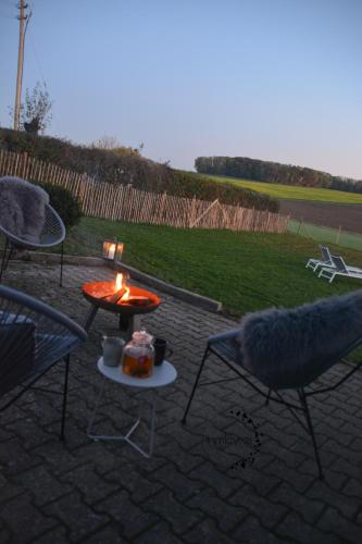 a patio with two chairs and a table with a fire at Landhaus Paco Familienferien mit Sauna und Kamin in Blaufelden