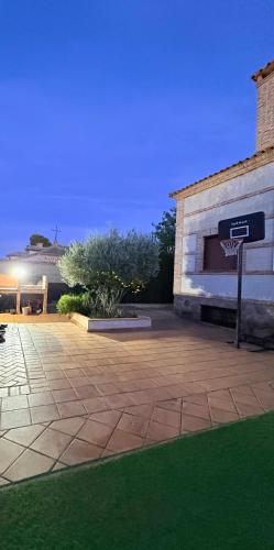 a building with a basketball hoop in a yard at Dos Olivas in Cobisa
