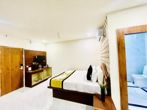 a bedroom with a bed and a bathroom at Hotel Eagle Grand Airport Zone in Shamshabad