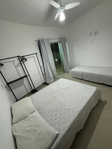 a bedroom with two beds and a ceiling fan at Residence Villa Vignoli in Arraial do Cabo