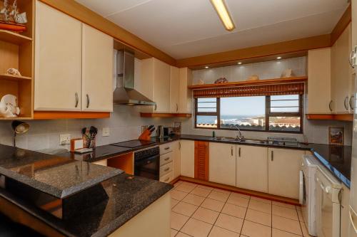 a kitchen with white cabinets and a large window at Ramsgate Mews 2 in Ramsgate
