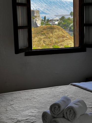 a bedroom with a window with towels on a bed at Guest House Salaria in Gjirokastër