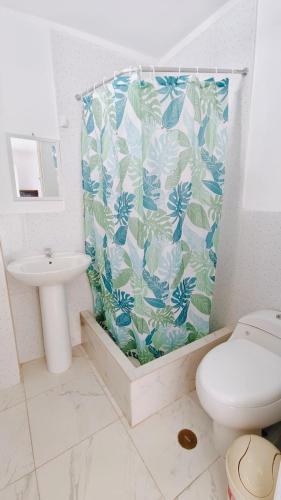 a bathroom with a toilet and a shower curtain at Icthus Paracas in Paracas