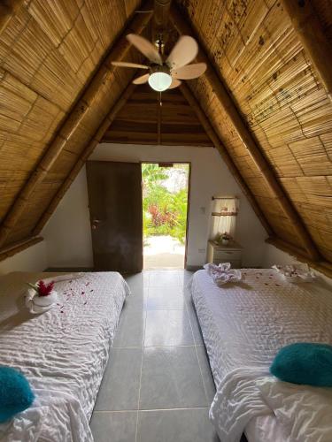 a bedroom with two beds and a ceiling fan at Eco Hotel Amanecer Tayrona in El Zaino