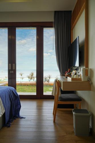 a bedroom with a desk with a computer on it at เดอะซีน คาบาน่า บีช รีสอร์ท ขนอม The Scene Cabana Beach Resort Khanom in Ban Plau