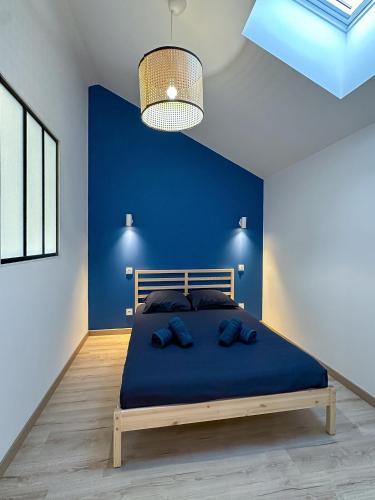 een slaapkamer met een blauwe muur en een bed met 2 kussens bij #LeBlue #Centre Ville in Cognac