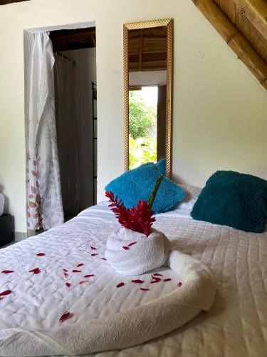 a bed with a towel with a flower on it at Eco Hotel Amanecer Tayrona in El Zaino