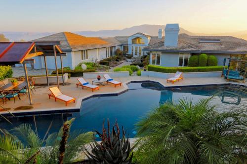 a home with a swimming pool and a house at Luxury Modern Chateau near wineries & beaches in Fallbrook