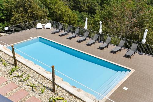 a swimming pool with chairs next to a fence at Casas das Olas in Arcos de Valdevez