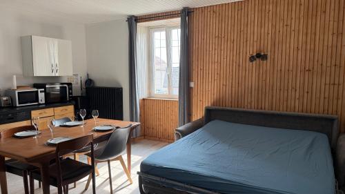 a bedroom with a bed and a table with chairs at Appartement spacieux in Frasne