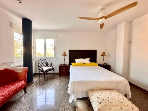 a bedroom with a large bed and a red couch at Villa Azahar - Mediterranean Retreat - in Alginet