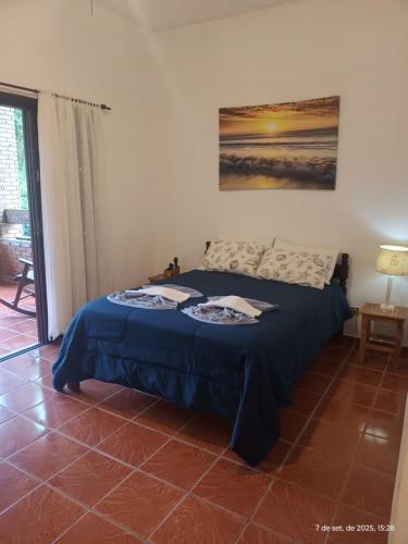 a bedroom with a bed with a blue blanket at Solar das Canoas Prumirim in Ubatuba