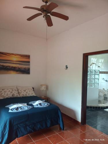 a bedroom with a ceiling fan and a bed at Solar das Canoas Prumirim in Ubatuba