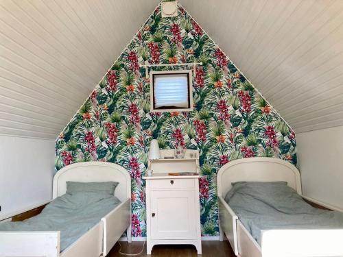 a attic bedroom with two beds and a wall mural at Near beach summer house in Farhultsbaden in Farhult