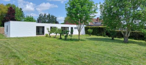 una casa blanca con árboles en un patio en Villa Del, en Moorslede