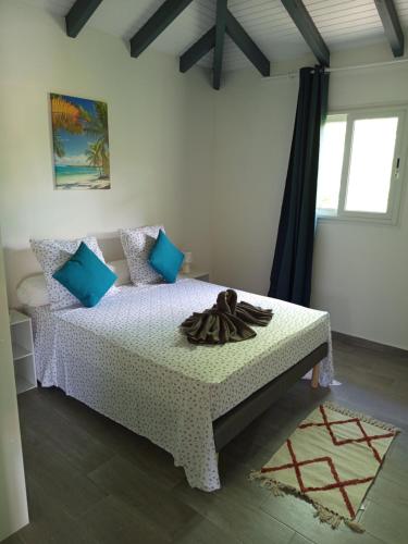 a bedroom with a white bed with blue pillows at Villa Lilisse in Le Moule