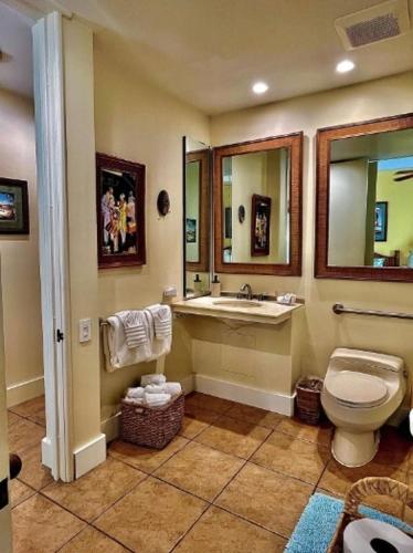 a bathroom with a toilet and a sink and a mirror at The Palms Unit 501, condo in Wailea