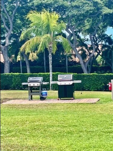 a park with a bench and a table and a palm tree at The Palms Unit 501, condo in Wailea