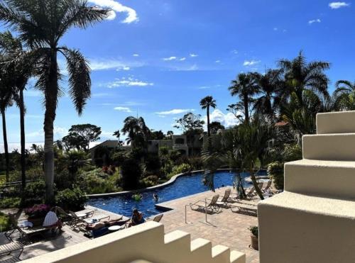 a swimming pool with palm trees and a resort at The Palms Unit 501, condo in Wailea