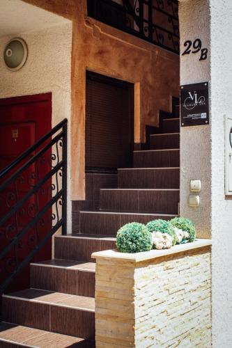 a set of stairs with potted plants in front of a building at Vladana DELUXE App 2 in Kruševac