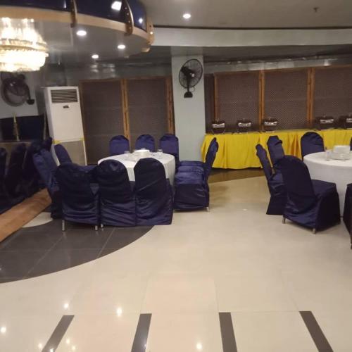 a room with blue chairs and a table in it at New Al-Safina Hotel in Lahore