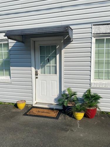a house with a door and two plants in front of it at Perfect in Pilot Mtn-Unit 1 Walk to Downtown! in Pilot Mountain