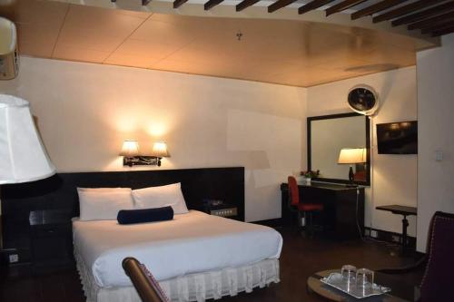 a bedroom with a white bed and a table and chairs at New Al-Safina Hotel in Lahore