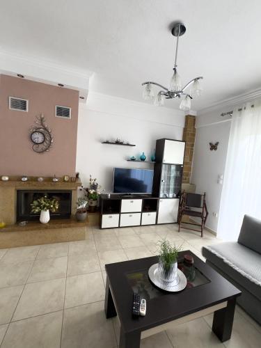 a living room with a couch and a tv at Nikos & Eleni Maisonette in Nea Fokea