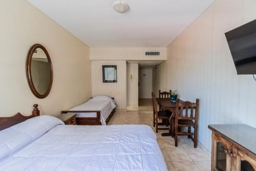 Un dormitorio con dos camas y una mesa y un espejo. en BA Departamentos Microcentro 4, en Buenos Aires