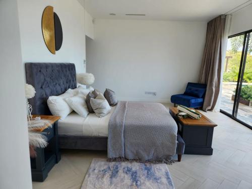a bedroom with a bed and a chair and a window at Rock House Estate in Bequia
