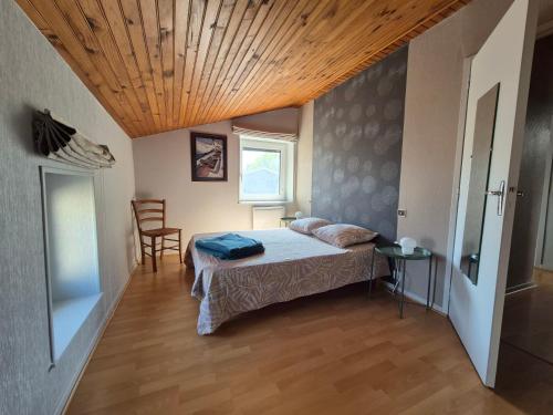 a bedroom with a bed and a wooden ceiling at Maison cozy dans les Volcans in Sayat