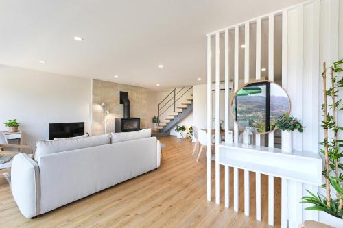 a living room with a white couch and a table at Casas das Olas in Arcos de Valdevez