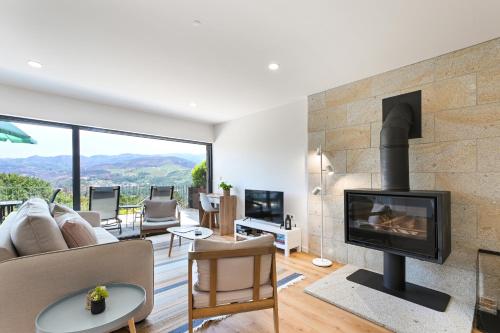 a living room with a fireplace with a view at Casas das Olas in Arcos de Valdevez