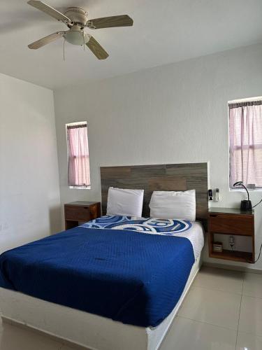 a bedroom with a blue bed with a ceiling fan at Padrisimo Departamento p6 personas en planta baja in Manzanillo