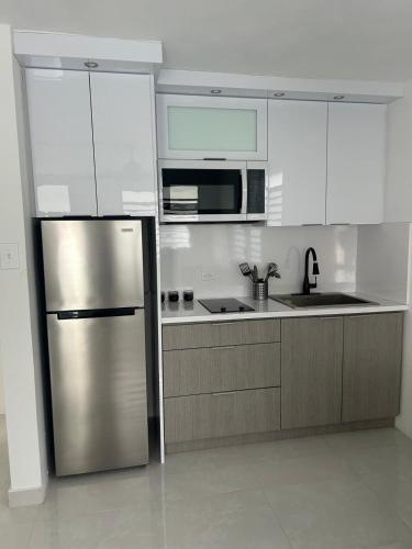 a kitchen with a stainless steel refrigerator and microwave at JC Apartment - One bedroom in Toa Baja