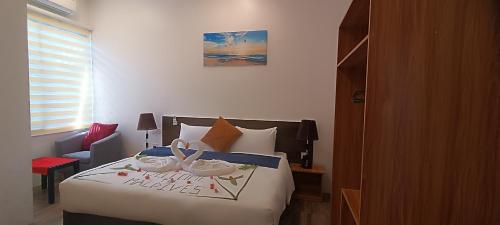 a bedroom with a bed with a happy new year sign on it at Manta Sky Inn in Dharavandhoo