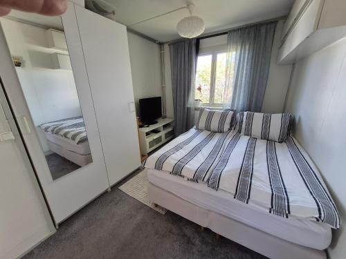 a small bedroom with a bed and a mirror at Lyckans Lodge in Dösjebro