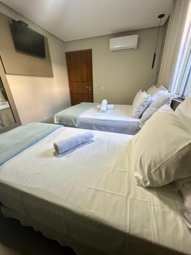 a hotel room with two beds with towels on them at Pousada Belvedere in Capitólio